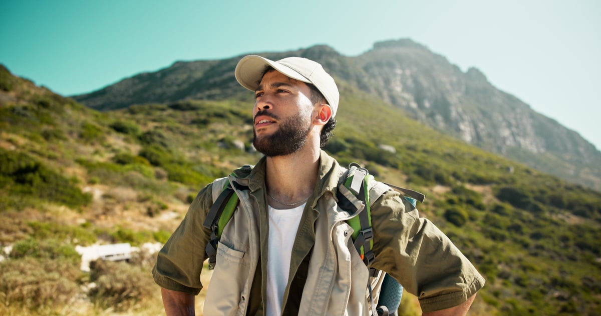 Caminante contemplando el paisaje de montaña durante una excursión de aventura